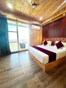 um quarto com uma cama grande e uma janela grande em The Walnaut Kasauli em Kasauli