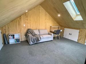 a room with a couch in the middle of a attic at Mill Creek Cottage in Arrowtown