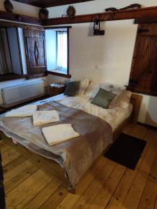 a large bed in a room with wooden floors at Сияние in Smolyan