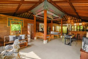 a large room with wooden walls and a large ceiling at Villa Asrava Ubud in Ubud
