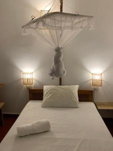 un letto con zanzariera sopra. di Unrushed Midigama a Midigama East