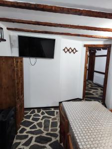 een slaapkamer met een bed en een flatscreen-tv bij Сияние in Smolyan
