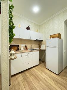 a kitchen with white cabinets and a white refrigerator at Nikita's Old Tbilisi in Tbilisi City