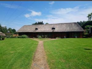 a large barn with a grass field in front of it at The Oaks Hotel in Richmond