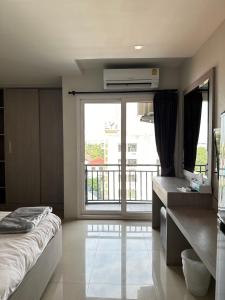 een slaapkamer met een bed en een groot raam bij DB Plus 2 in Ban O Pao