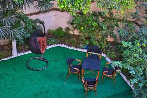 twee stoelen en een tafel op een groen gazon bij Egyptus Villa Hostel in Alexandrië