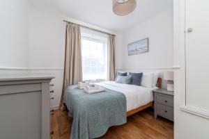 Spacious 3BR house wbalcony, South London في لندن: غرفة نوم بيضاء بها سرير ونافذة