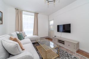 Spacious 3BR house wbalcony, South London في لندن: غرفة معيشة مع أريكة وتلفزيون