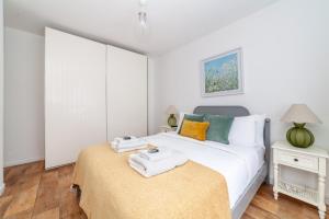 a bedroom with a bed with towels on it at Spacious 3BR house wbalcony, South London in London
