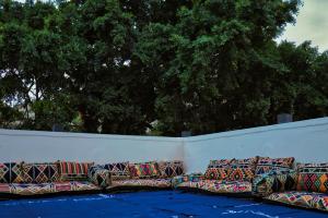 una fila de coloridos sofás sentados contra una pared en Egyptus Villa Hostel en Alexandría