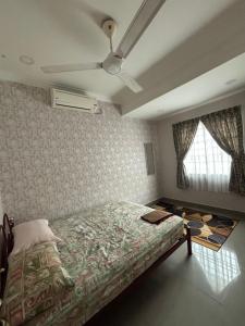 a bedroom with a bed and a ceiling fan at Embun Selasih Homestay in Pasir Gudang