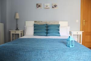 a bedroom with a large bed with blue pillows at Apartamentos Vino y Camino in Nájera