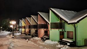 uma fila de casas cobertas de neve à noite em Tatralandia Apartmán em Liptovský Mikuláš