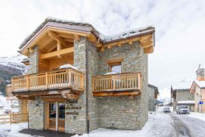 a log house with two decks on the side of it at Chalet la Parrachée in Lanslebourg-Mont-Cenis