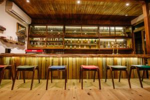 a bar with green and red stools at Irori Guest House Tenmaku in Hakone