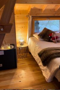 um quarto com uma cama num chalé de madeira em Cabane perchée luxe avec jacuzzi Domaine du Marais Maisse em Maisse