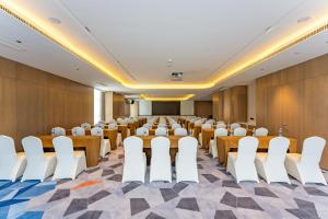 Holiday Inn Express Suzhou Bay, an IHG Hotel في سوتشو: قاعة اجتماعات مع طاولات وكراسي في المنتصف