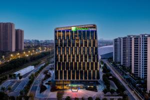 um edifício alto com um sinal em cima em Holiday Inn Express Suzhou Bay, an IHG Hotel em Suzhou