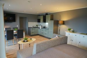 a living room with a couch and a kitchen at Aparthotel Rotheul in Rotheul