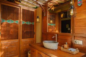 a bathroom with a bowl sink on a wooden counter at Villa Asrava Ubud in Ubud