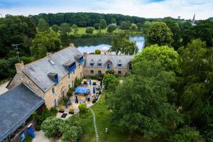 Vue aérienne d'un bâtiment avec une rivière en arrière-plan dans l'établissement Logis Hôtel Le Manoir Des Portes, à Lamballe