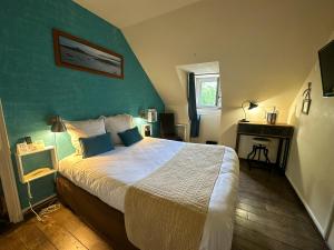 A bed or beds in a room at Logis Hôtel Le Manoir Des Portes