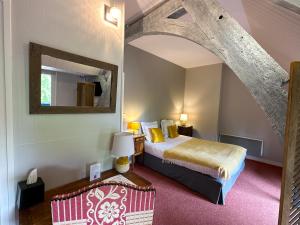 A bed or beds in a room at Logis Hôtel Le Manoir Des Portes