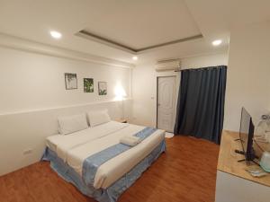 a bedroom with a bed and a television in it at Inspire House Hotel in Chiang Mai
