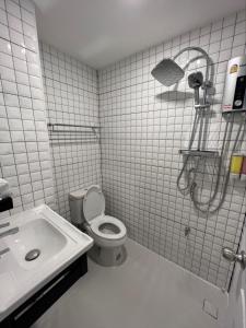 La salle de bains blanche est pourvue de toilettes et d'un lavabo. dans l'établissement Inspire House Hotel, à Chiang Mai