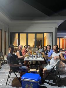 een groep mensen die rond een tafel zitten bij 12_LUXURY VILLA COASTAR HỒ TRÀM RESORT ll Private pool ll large garden ll BBQ next to the HAMPTONS 300m - beautifull beach in Xuyên Mộc