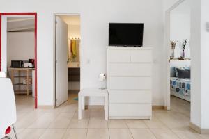salon z telewizorem na białej ścianie w obiekcie Bungalow Aloe Dunas 2 w mieście Maspalomas