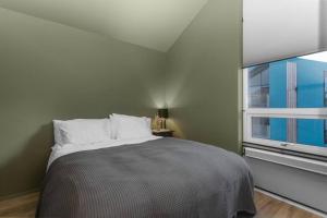 a bedroom with a bed and a large window at Luxury down town/Free parking in Reykjavík