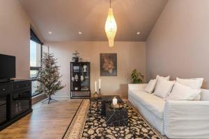a living room with a white couch and a christmas tree at Luxury down town/Free parking in Reykjavík