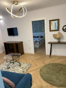 a living room with a blue couch and a bed at Alex Apartament Central in Bucharest