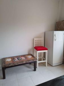 a room with a table and a refrigerator and a stool at Mountain view apartment in Makadi Heights in Hurghada