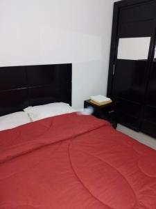 a bedroom with a red bed with a red blanket at Mountain view apartment in Makadi Heights in Hurghada