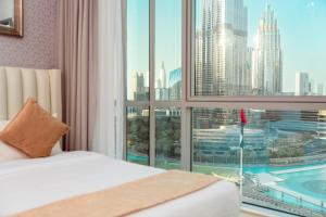 a bedroom with a large window with a view of a city at Elite Royal Apartment - T3 - Full Burj Khalifa & fountain view in Dubai