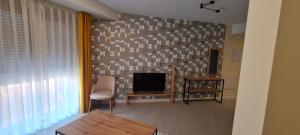 a living room with a table and a television at BYS SANTA FE APARTAMENTOS TURISTICOS in Lorca