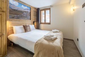 ein Schlafzimmer mit einem Bett mit Handtüchern darauf in der Unterkunft Chalet La Turra, Spa privée in Lanslebourg-Mont-Cenis