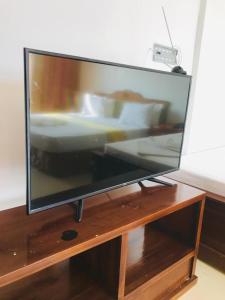 een grote flatscreen-tv zittend op een houten standaard bij Hotel Dream Paradise in Ja-Ela