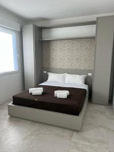 1 dormitorio con 1 cama grande y 2 toallas. en STRUTTURA DINI B en Padova