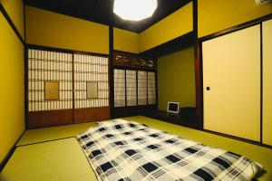 Habitación con cama en el medio de una habitación en 北房まちの駅 ゲストハウス en Maniwa