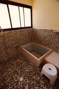 uma casa de banho com uma banheira e um WC. em 北房まちの駅 ゲストハウス em Maniwa
