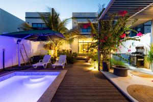 富查伊拉的住宿－Al Dana Paradise Luxury Villas Palm Fujairah Sea View，庭院设有热水浴池、椅子和遮阳伞。