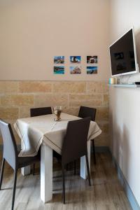 Lido degli Angeli Case Vacanza-Beach في بونتا بروسسيوتو: غرفة طعام مع طاولة مع كراسي وتلفزيون