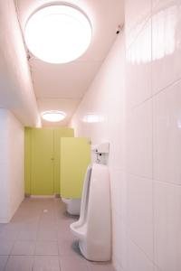 台中市にあるKiwi Express Hotel - Chenggong Rdのバスルーム(2つの尿、照明付きの天井)