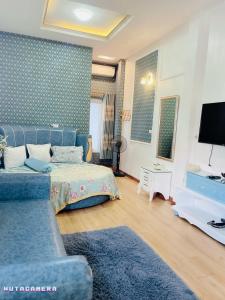 uma sala de estar com um sofá azul e uma televisão em Luxury Hotel T&L em Cẩm Phả