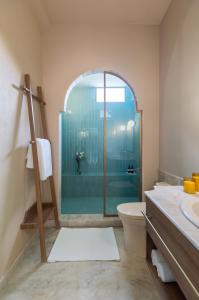 a bathroom with a shower and a toilet and a sink at Manuscript - Jhilwara Haveli in Udaipur