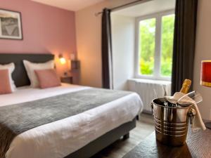 A bed or beds in a room at Logis Hôtel Le Manoir Des Portes