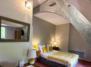 A bed or beds in a room at Logis Hôtel Le Manoir Des Portes